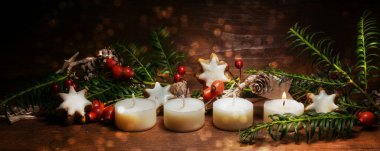Koyu renk ahşap, panoramik format, kopyalama alanı, seçili odaklanma üzerine Noel süslemesi olan ilk Advent için bir küçük mum yakıldı.