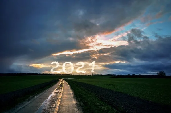 시골길의 반영은 어두운 들판을 미래의 2021의 구름낀 하늘로 나아가고 있습니다 — 스톡 사진