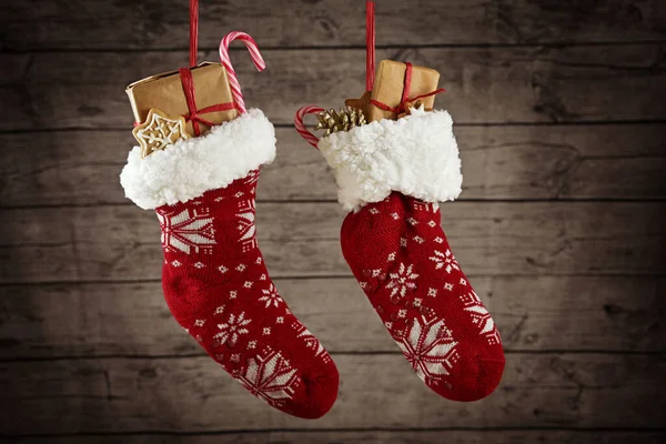 Pair Christmas Stockings Filled Gifts Sweets Hanging Front Rustic Wooden — Stock Photo, Image