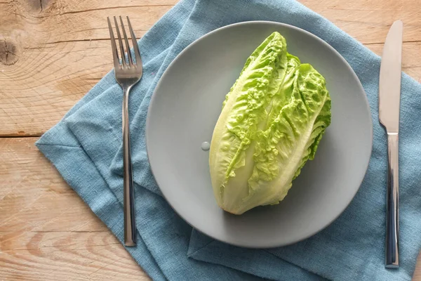 新鲜的绿色生菜或婴儿 因为在灰色的盘子里 有餐具和蓝色餐巾和乡村式木板 健康的素食概念可以减肥 复制空间 从上方看高角度 — 图库照片