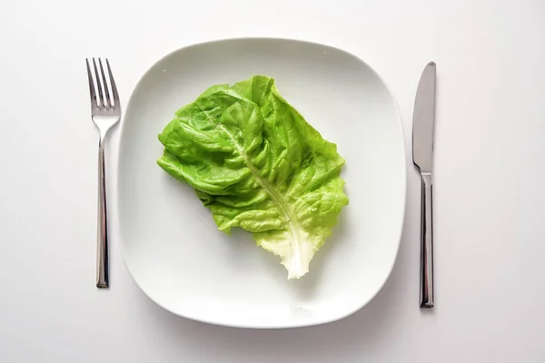 Grünes Salatblatt Auf Quadratischem Teller Und Besteck Auf Weißem Hintergrund — Stockfoto