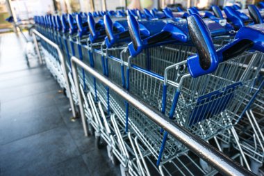 Covid-19 salgını, kopyalama alanı ve seçili odak noktası nedeniyle perakende satış mağazası önünde müşterileri bekleyen mavi alışveriş arabaları