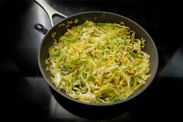 黒いストーブの上にフライパンでキャベツをサヴォイ 健康的な冬の野菜と自宅で調理 選択された焦点 フィールドの狭い深さ — ストック写真