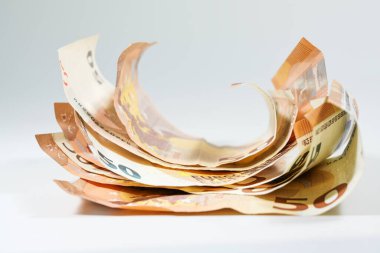 Açık gri arka plan, para ve finans konsepti, kopyalama alanı, seçili odak alanı, dar alan derinliği üzerine yarım yuvarlanmış 50 avroluk banknot yığını