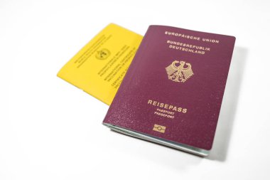 Alman pasaportu ve sarı Aşı Sertifikası beyaz zemin üzerinde izole edilmiş, seyahat gereksinimi SARS-CoV-2 Covid-19 Coronavirus bağışıklığı, kopyalama alanı, seçilmiş odak alanı, dar alan derinliği için bir rekordur.
