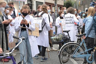 Lubeck, Almanya, 24 Eylül 2021: Beyaz önlüklerinde Almanca sloganlar olan tıp sektöründen genç insanlar, bu demektir ki - Sağlık, gelecekteki gösteriler için küresel Cuma günleri İklim Korumasına ihtiyaç duyar, seçilmiş odak noktası