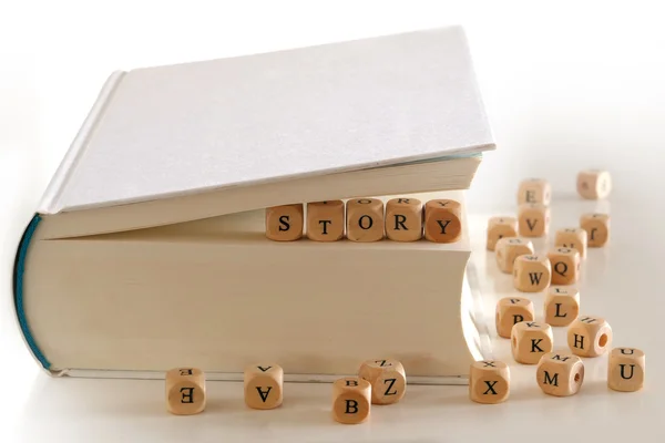 Story - message  with wooden letter blocks between pages of a  b — Stock Photo, Image