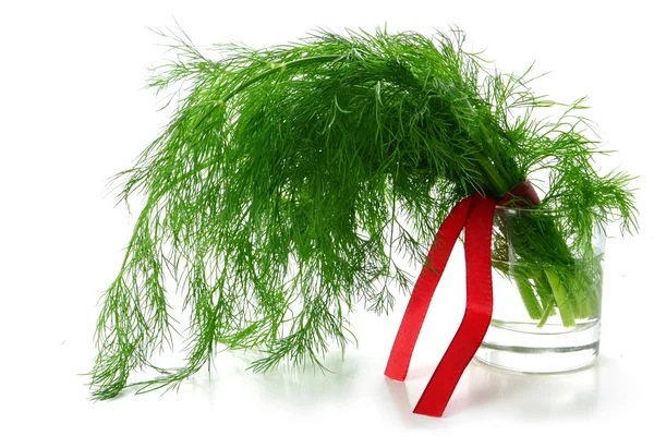 Dill bos met een rood lint in een glas met water, geïsoleerd op — Stockfoto