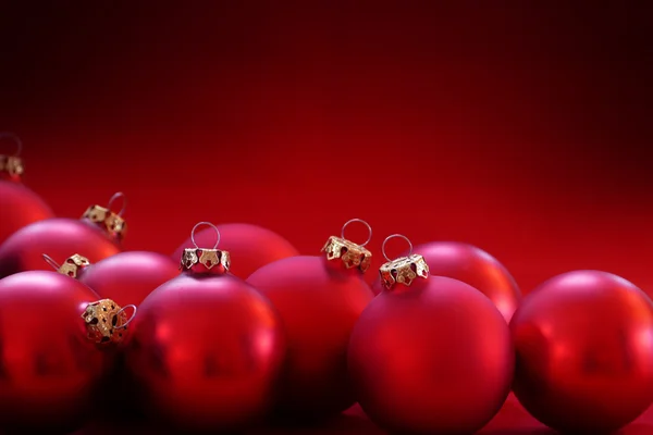 Red christmas baubles on red background, copy space — Stock Photo, Image