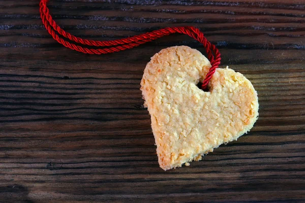 Soubor cookie srdce s červenou stuhou na tmavé staré dřevo, kopie prostor — Stock fotografie