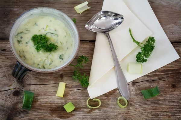 Soupe à la crème de légumes avec poireau dans un bol en terre cuite sur un rustique — Photo