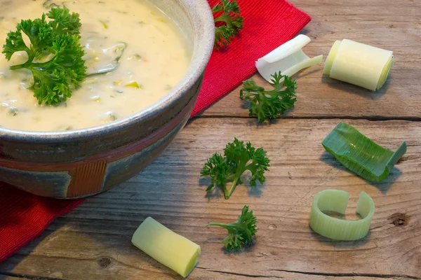 Creme sauce in a bowl with fresh leeks and herbs on  rustic wood — Stock Photo, Image