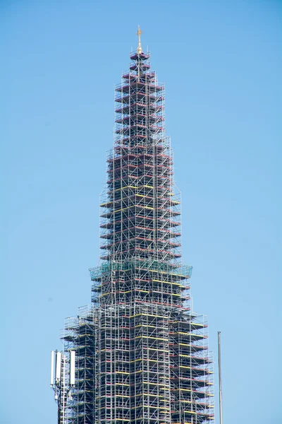 Kerktoren met steigers tegen blauwe hemel — Stockfoto
