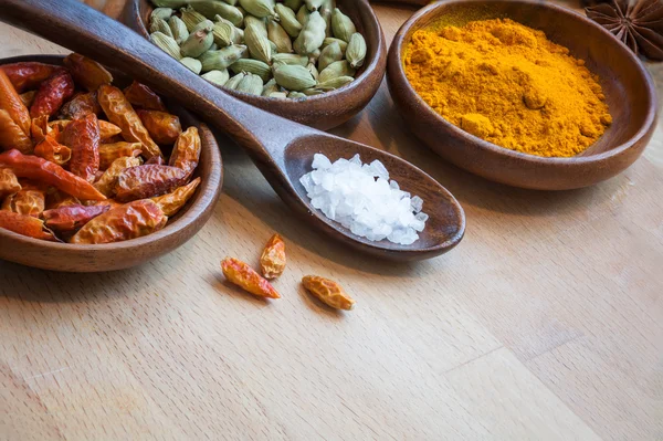 Pimentão vermelho, cardamomo e curcuma em taças wodden, especiarias como corne — Fotografia de Stock