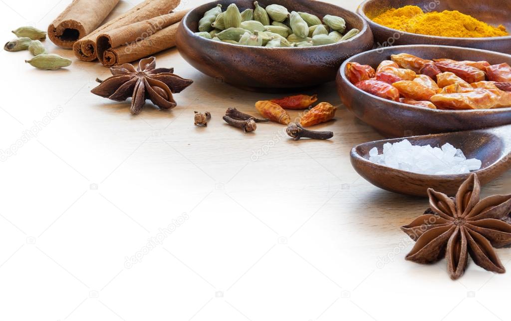 exotic spices in wodden bowls, corner background blurred to whit