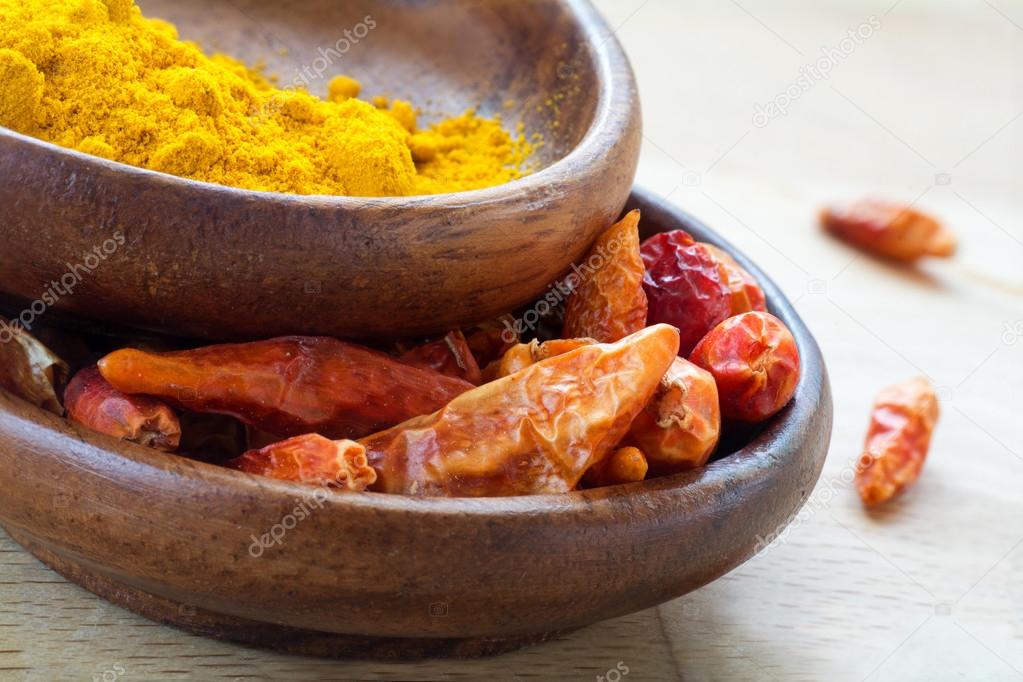 Asian spices, dried red chili and curcuma in wooden bowls