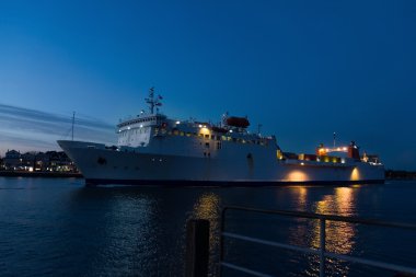 gemi bir küçük liman kenti akşam geç geçer.