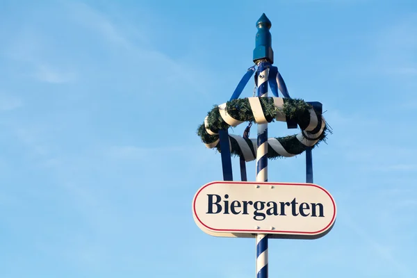 Kranz und Schild als Zeichen für einen bayerischen Biergarten — Stockfoto