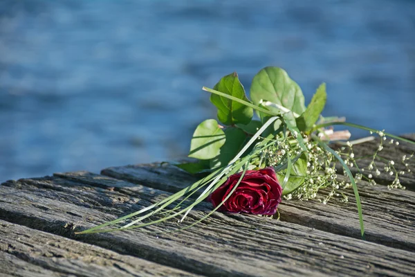 Último saludo de amor, ramo de rosas en el viejo muelle de madera después de un —  Fotos de Stock