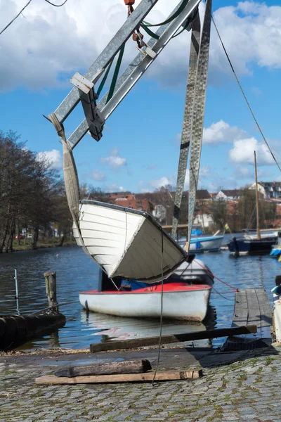 Grue de bateau soulève le bateau dans l'eau, verticale — Photo