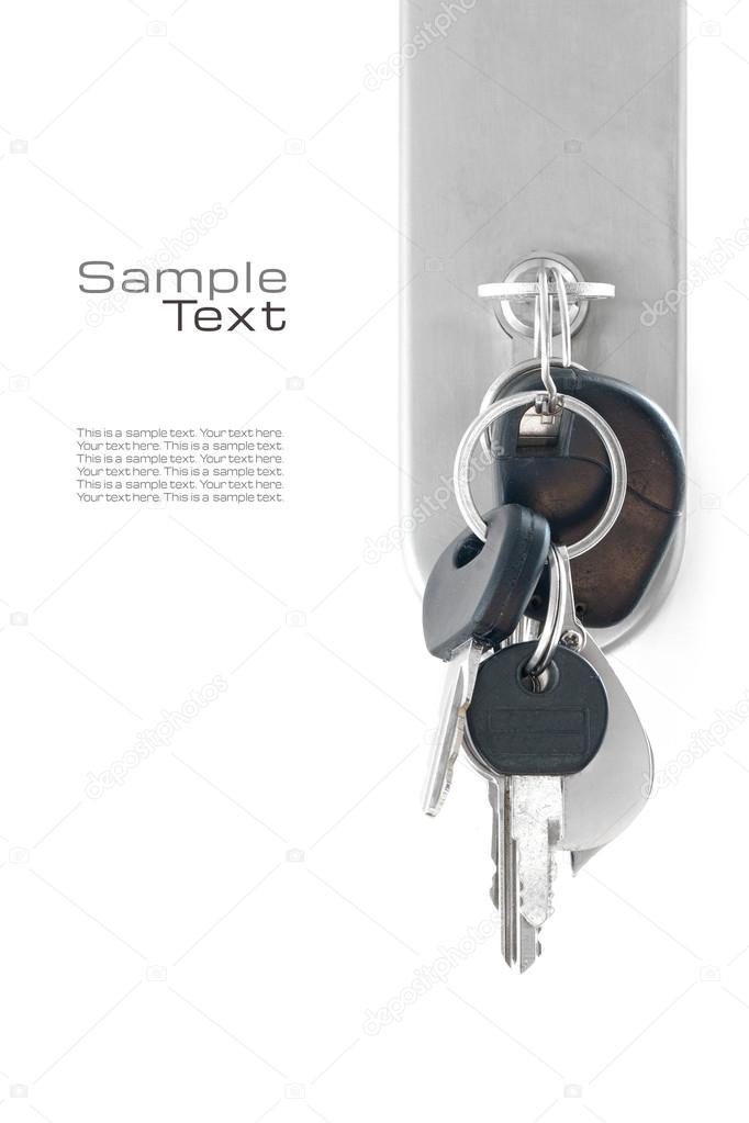 bunch of keys at the lock of a front door, isolated on white