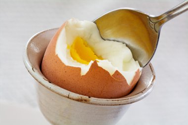 Bir haşlanmış yumurta ve bir kaşık ile seramik yumurtalık