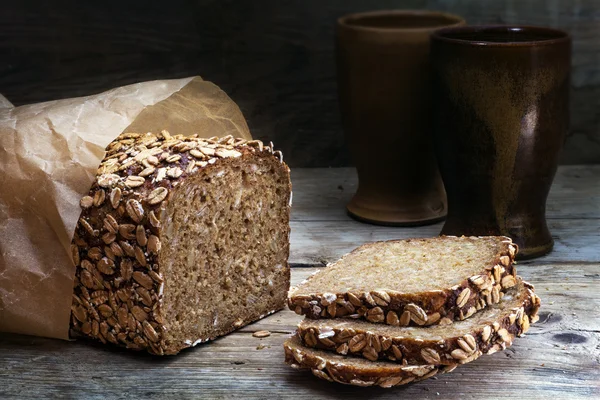 Teljes kiőrlésű kenyér, magvak, viharvert fa, sötét háttér — Stock Fotó