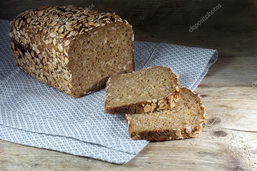 Bread loaf with whole grain and seed on rustic wood, dark backgr Stock