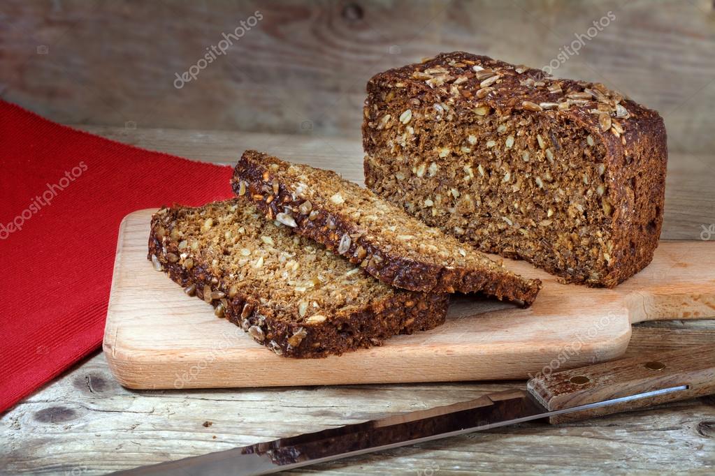 Fresh dark rye bread with whole grain on rustic wood — Stock Photo © fermate 71246991