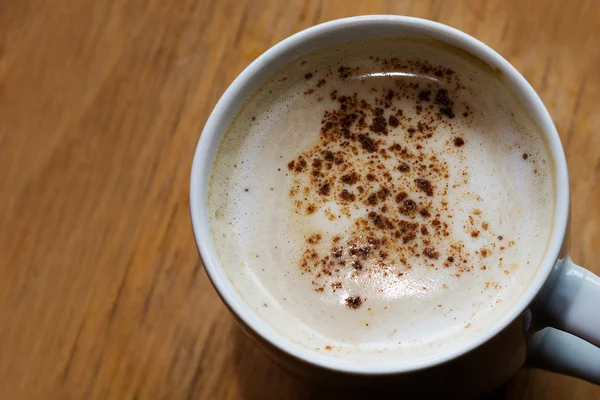 Coffee with milk foam and cocoa on a wooden table, copy space — Stock Photo, Image