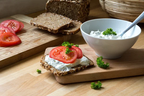 Curd cheese dip with herbs and rustic wholegrain bread with toma — Stock Photo, Image