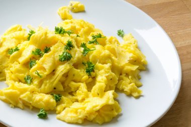 scrambled eggs with parsley garnish on a plate clipart