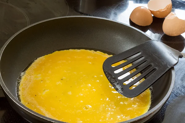 Liquid egg in the pan for pancakes or scrambled eggs — Stock Photo, Image