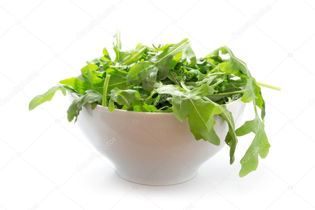 rucola or arugula, fresh green rocket salad  in a white bowl, is