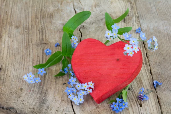 Kırmızı ahşap kalp şekli ile forgett-beni-değil flowerd eski ahşap üzerine — Stok fotoğraf