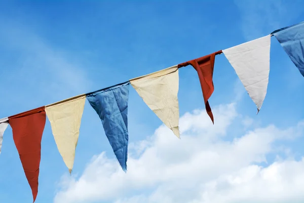 Prapory vlajky visí proti modré obloze mraky — Stock fotografie