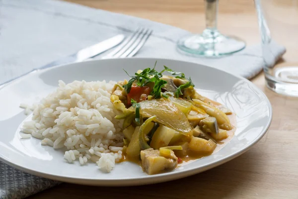 Желтый овощной карри с рисом на белой тарелке — стоковое фото