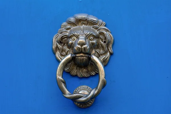 Tête de lion porte frappeur sur une porte bleue — Photo