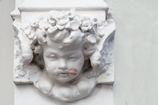 Cherub auf einem Gebäude mit einem Lippenstiftkuss auf die Wange — Stockfoto