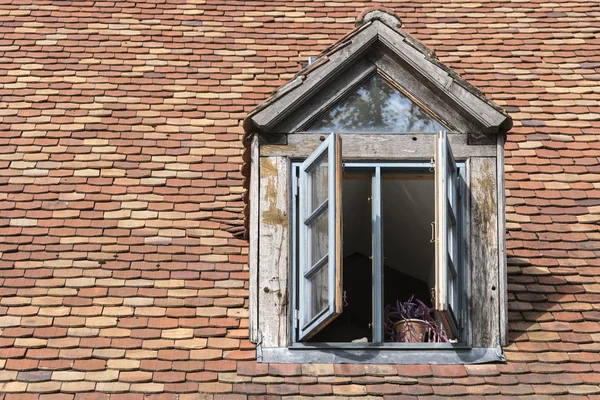 Offenes Fenster in einer alten Dachgaube mit historischem "Bibertai" — Stockfoto