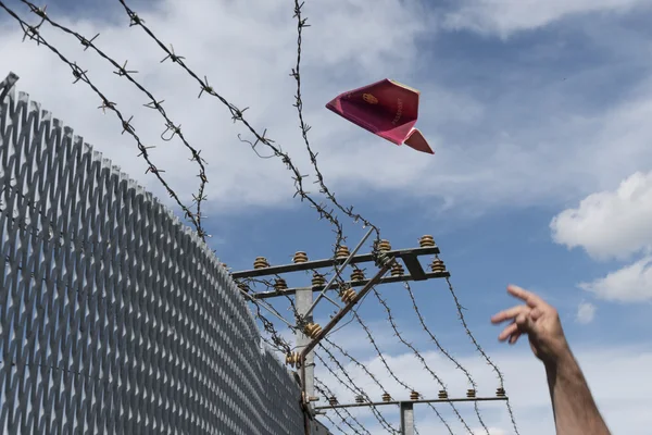 Man's hand throwing his passport folded as a paper airplane over — Stok fotoğraf