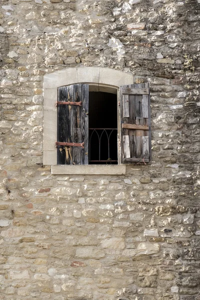 Gebouw gemaakt van natuursteen met een venster en half-open shutt — Stockfoto