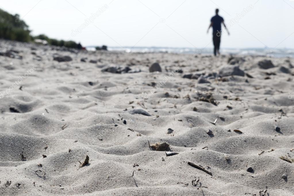 blurred silhouette of a man walking on the beach