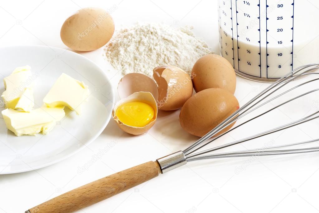 Baking ingredients for pancakes, butter, eggs, flour, milk and a