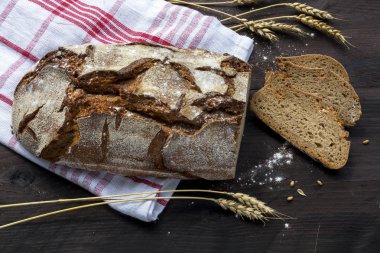 rustik ekmek somun ve buğday dilimlerle kulaklar bir koyu ahşap ta