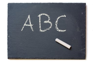 Kara tahta tebeşir ve üzerinde beyaz izole harfler A, B, C,
