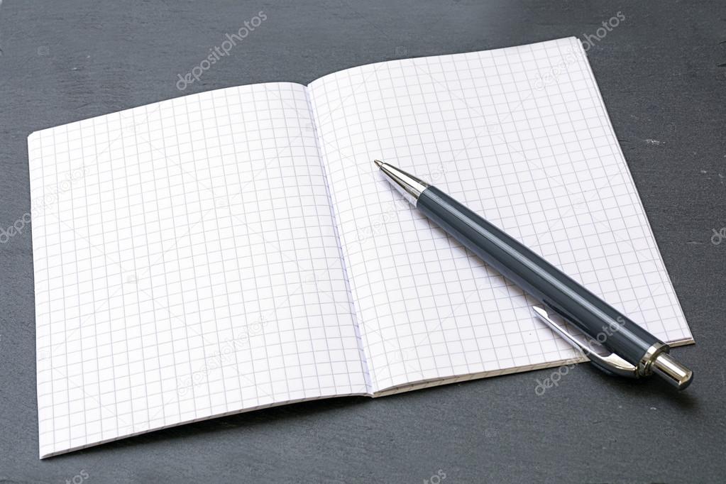 ballpoint pens and a blank notebook with graph paper