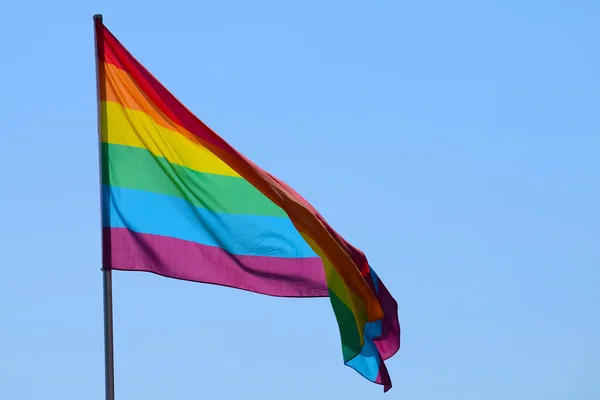 Bandera del arco iris contra el cielo azul — Foto de Stock