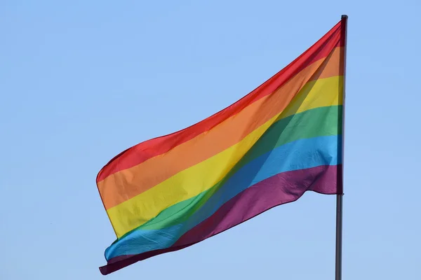 Bandeira do arco-íris contra o céu azul — Fotografia de Stock