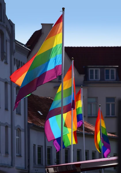 Lysande regnbåge flaggor i skumma gamla stan — Stockfoto